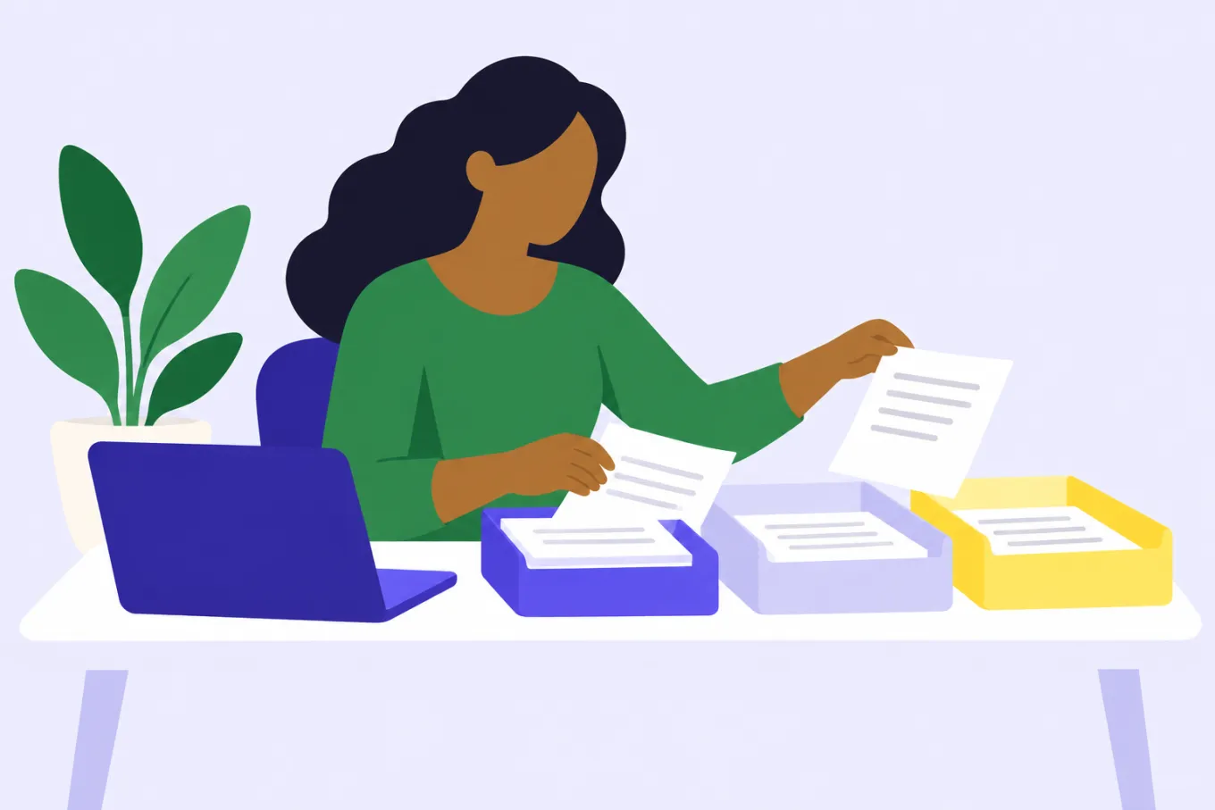 Una dueña de negocio en su escritorio reparte documentos en tres bandejas de colores distintos, junto a su laptop.
